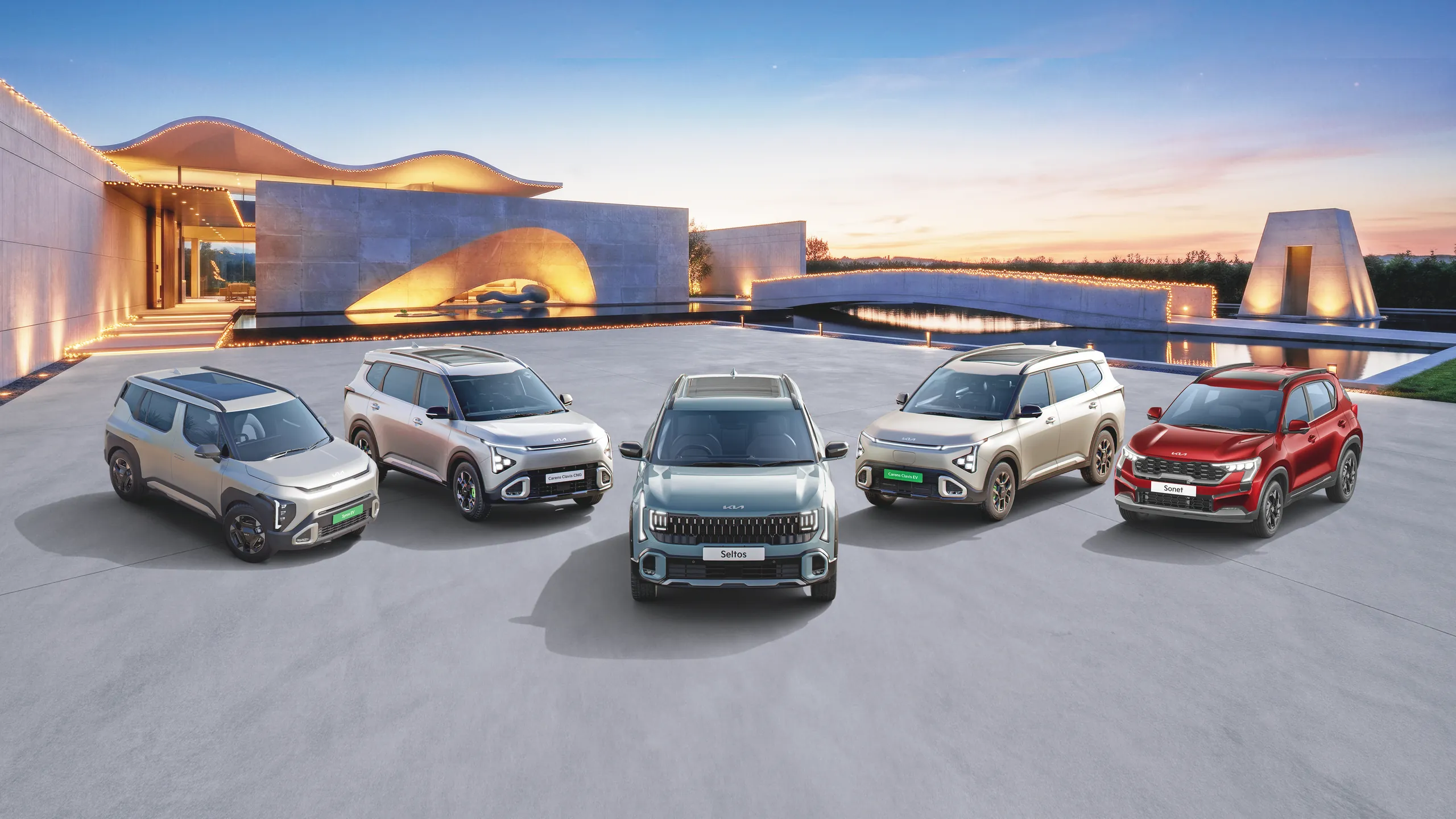 The Kia line-up outside a modern Kia showroom